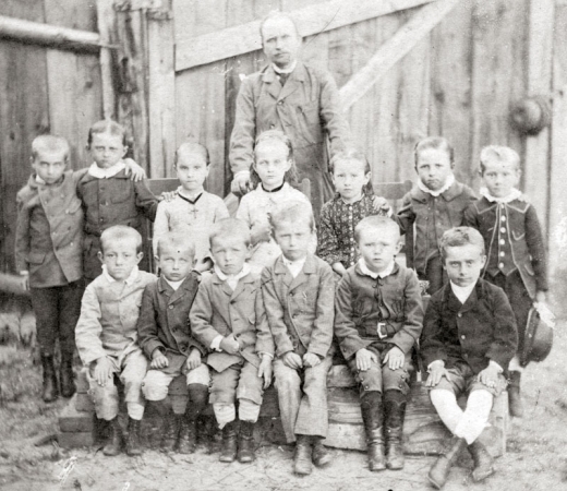 Druhý sedící zleva je žák II. třídy obecné školy ve Zbiroze, Fráňa Šrámek, který školu navštěvoval v letech 1883–1885